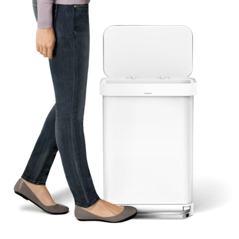 Person standing next to a white trash can on a white background